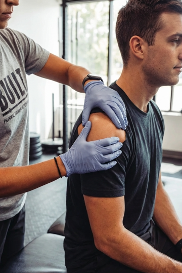Patient receiving manual therapy treatment at a CrossFit-focused physical therapy clinic in Valparaiso